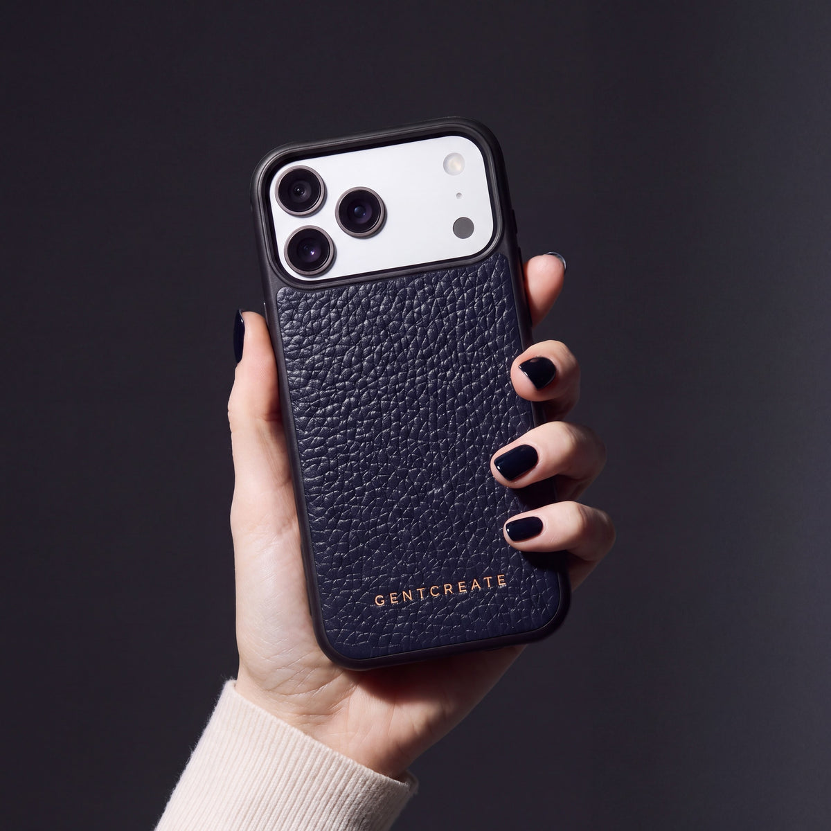 Hand with navy nails holding a navy pebble-grain calfskin iPhone 18 Pro Max case by GENTCREATE