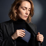 Woman in a blazer holding a navy Saffiano leather bifold wallet by GENTCREATE