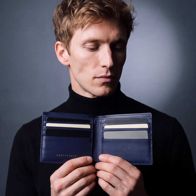 Man opening a navy Saffiano leather bifold wallet by GENTCREATE to show the card slots
