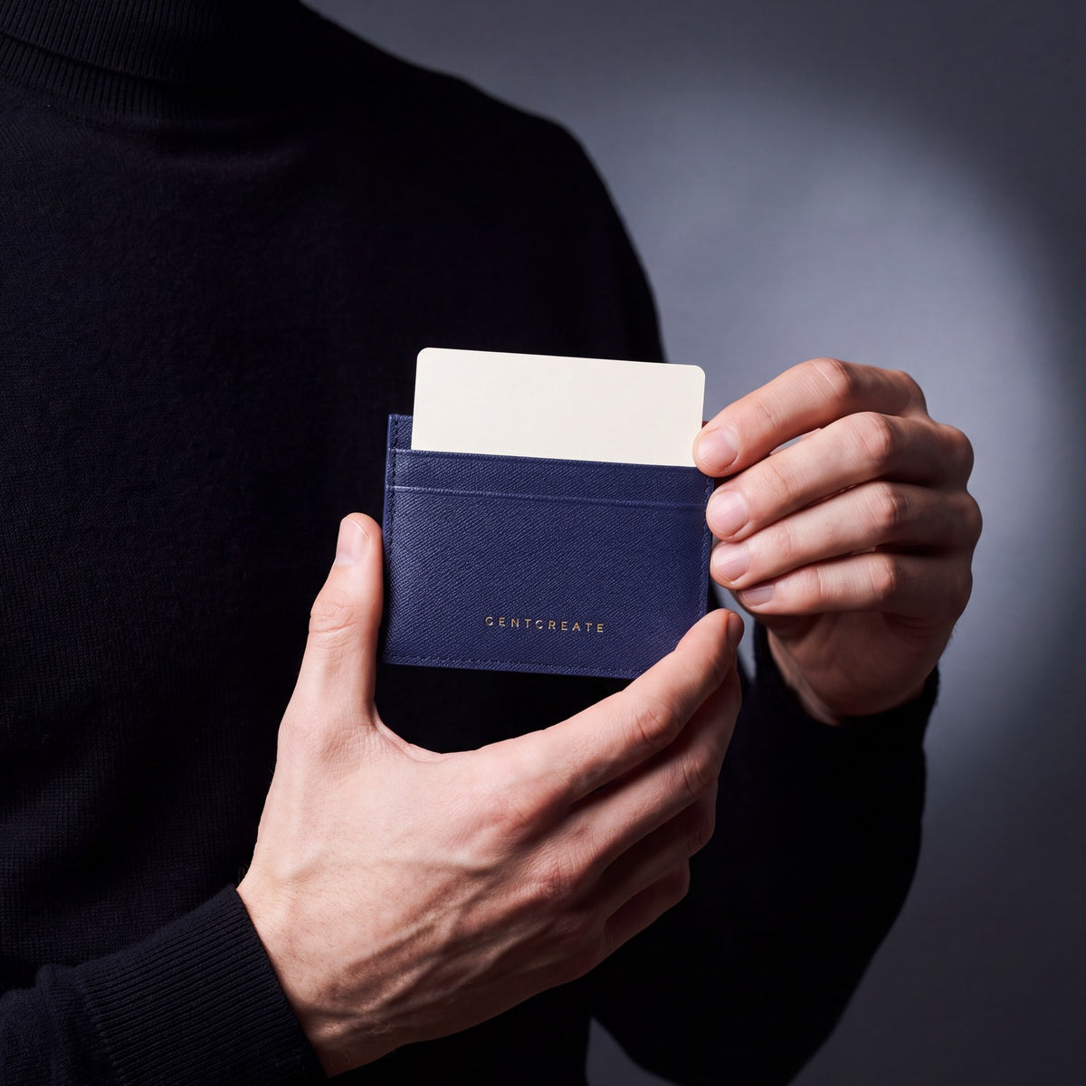 Close-up of hands holding a navy Saffiano leather card holder by GENTCREATE with a card in the top slot