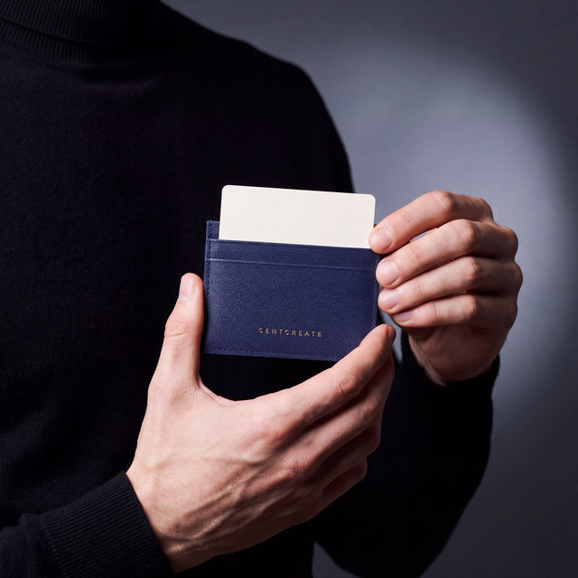 Close-up of hands holding a navy Saffiano leather card holder by GENTCREATE with a card in the top slot