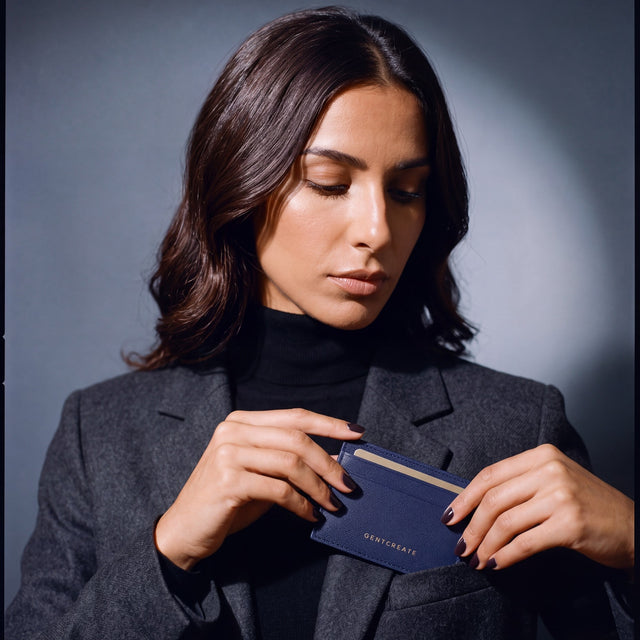 Woman slipping a navy Saffiano leather card holder by GENTCREATE into a blazer chest pocket