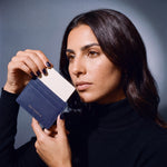 Woman holding a slim navy Saffiano leather card holder by GENTCREATE and drawing out a card