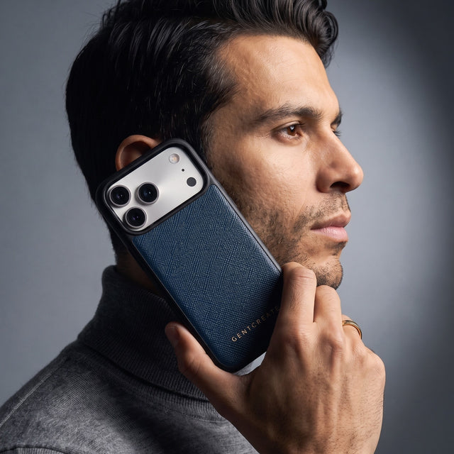 Man holding a navy Saffiano cross-hatch calfskin iPhone 18 Pro Max case by GENTCREATE against his jaw
