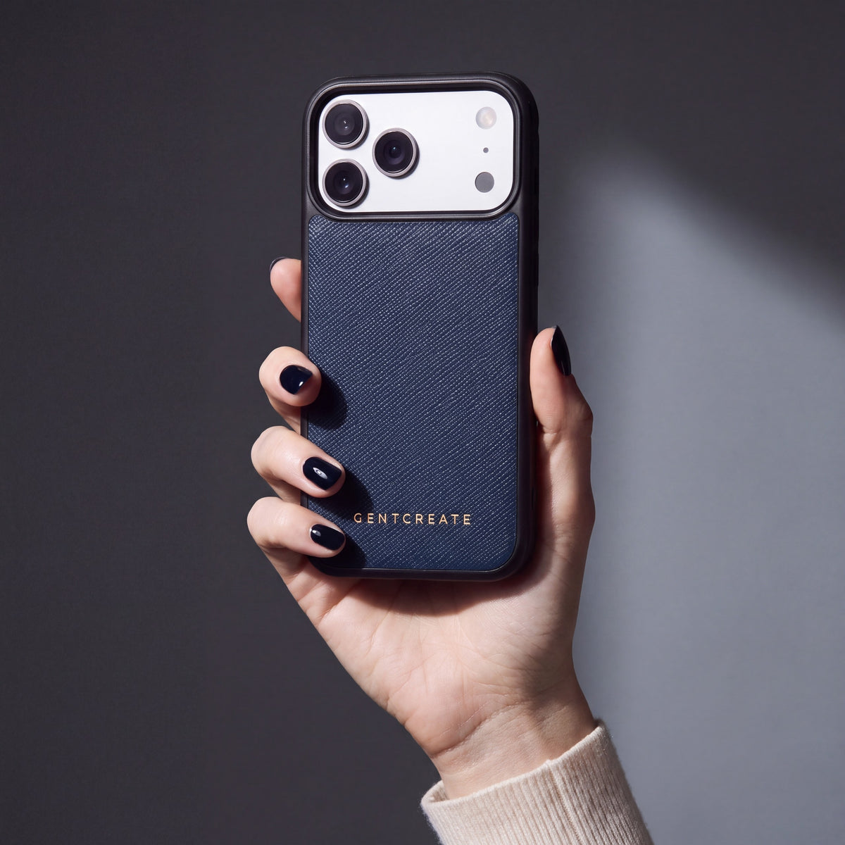Hand with navy nails holding a navy Saffiano cross-hatch calfskin iPhone 18 Pro Max case by GENTCREATE