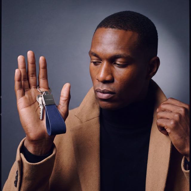 Man heading out with house keys on a navy Saffiano leather keychain by GENTCREATE