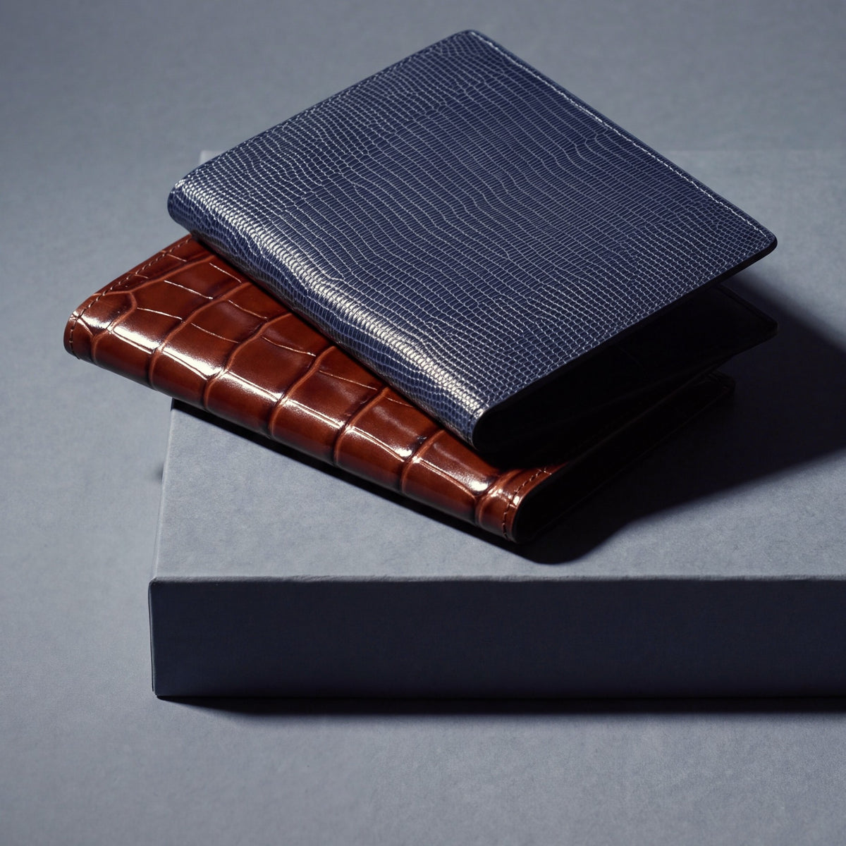 Passport holders by GENTCREATE in crocodile-embossed and lizard-embossed leather, stacked