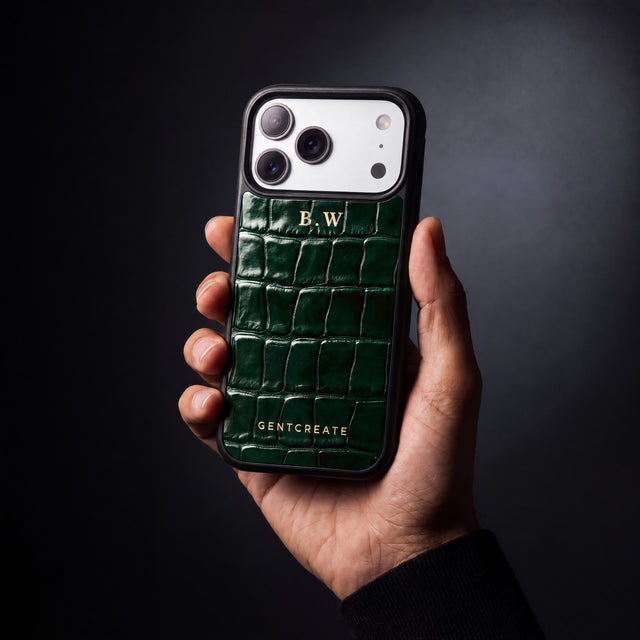 يد رجل تمسك جرابًا أخضر لهاتف iPhone 18 Pro Max بنقش التمساح البارز من GENTCREATE يحمل الحرفين الأولين B.W بختم حراري ذهبي