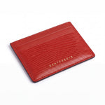 Red lizard-embossed leather business card holder by GENTCREATE lying at an angle on white
