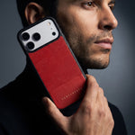Man holding a red lizard-embossed leather iPhone 18 Pro Max case by GENTCREATE against his jaw