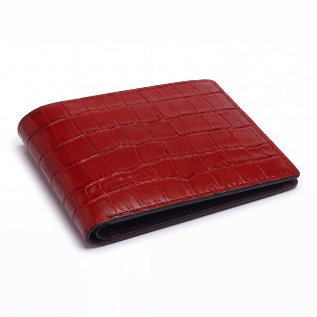 Closed red matte crocodile-embossed leather bifold wallet by GENTCREATE lying on white