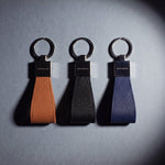 Saffiano leather keychain by GENTCREATE in brown, black and navy, laid flat