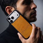 Man holding a yellow lizard-embossed leather iPhone 18 Pro Max case by GENTCREATE against his jaw