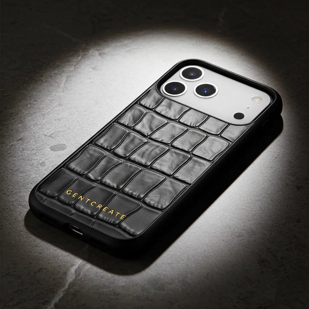 Black crocodile-patterned iPhone 17 case with 'GENTCREATE' branding on a dark background