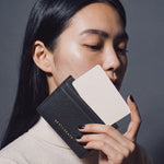 Woman sliding a card into a slim black pebble leather card holder by GENTCREATE, video