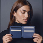 Woman opening a navy lizard leather bifold wallet by GENTCREATE to show the card slots, video