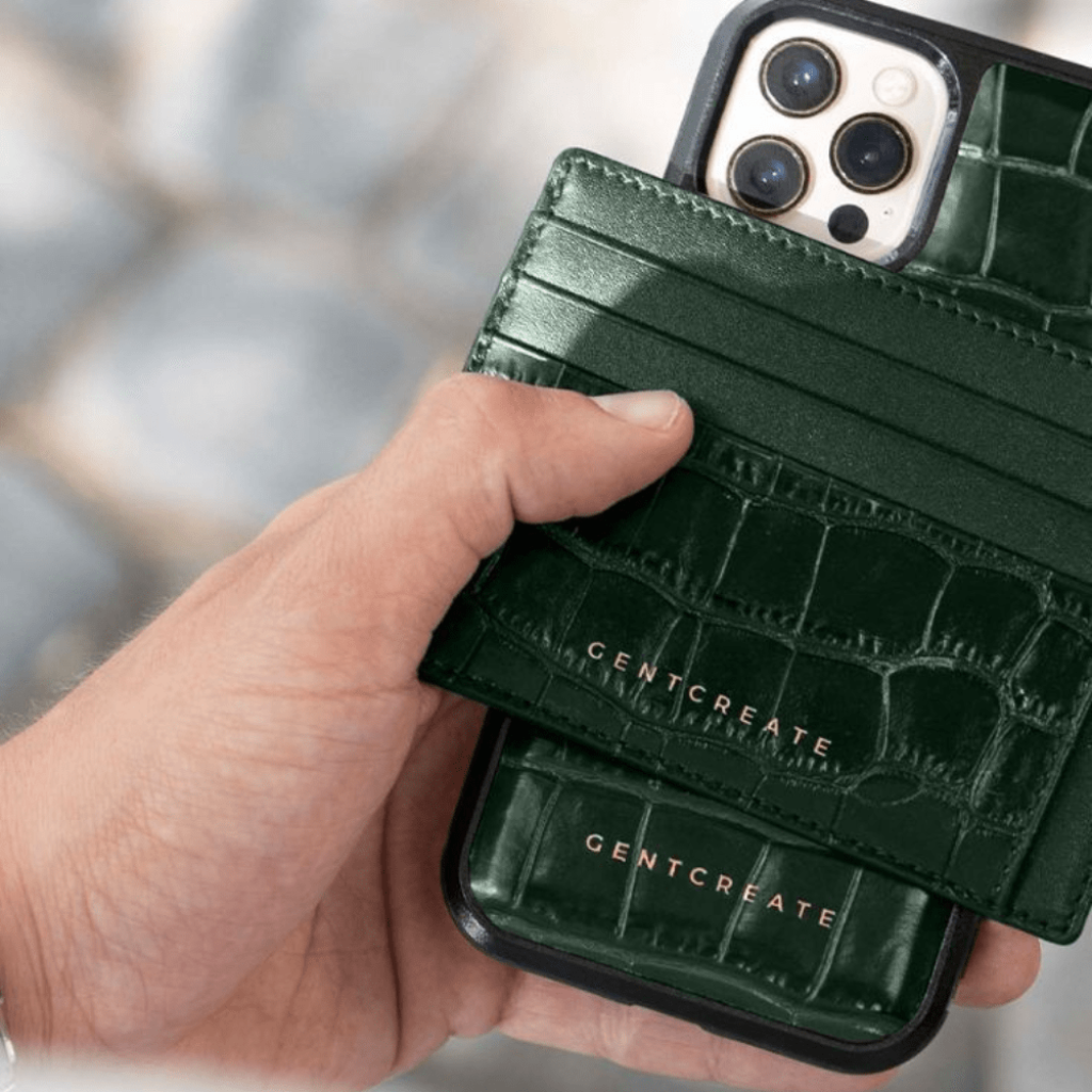 A man is holding a green glossy leather iPhone case and a green glossy card holder from by Gentcreate.