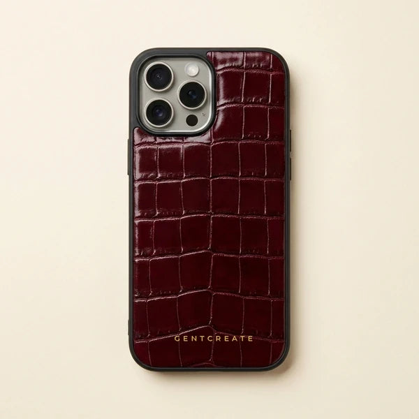 Capa para iPhone em pele bordeaux gravada a crocodilo, com bordo em borracha preta e um pequeno logótipo GENTCREATE a dourado